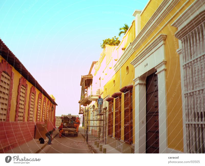 Men@Work Stadt kolonial Kolonialstil Haus Wand rot gelb Müll Müllwagen Baustelle Bauarbeiter Physik historisch alt Himmel blau PKW Sonne Wärme Architektur