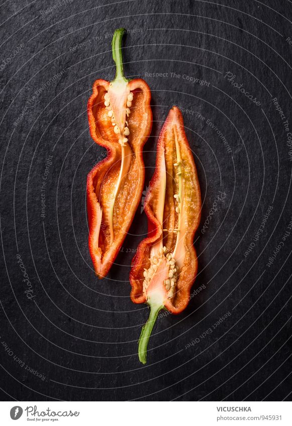 Halbierte rote Paprika. Lebensmittel Gemüse Ernährung Bioprodukte Vegetarische Ernährung Diät Lifestyle Natur schwarz Hintergrundbild Chili Vitamin Teilung lang