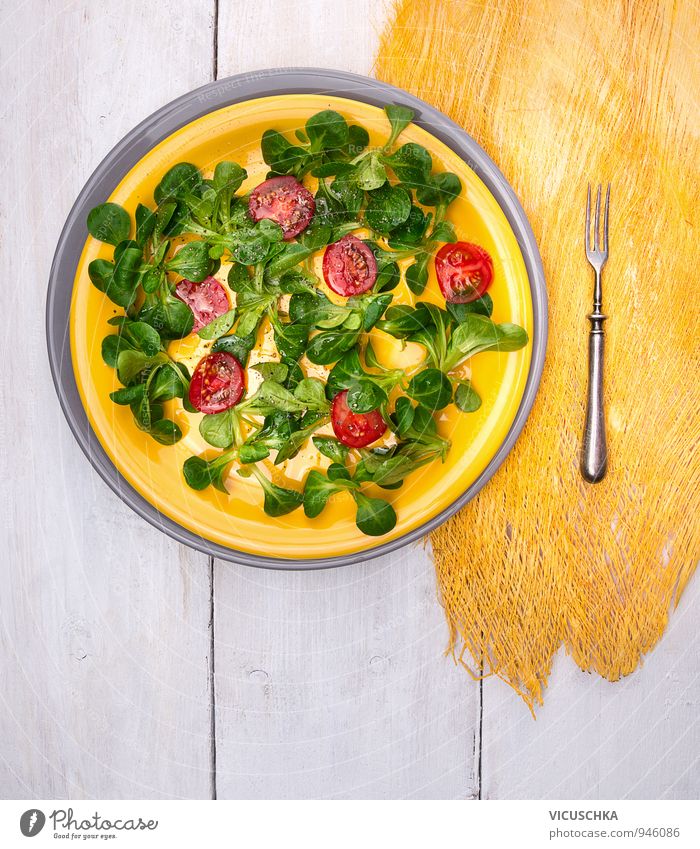 Feldsalat und Tomaten in gelbe Platte Lebensmittel Gemüse Salat Salatbeilage Kräuter & Gewürze Öl Ernährung Mittagessen Festessen Bioprodukte