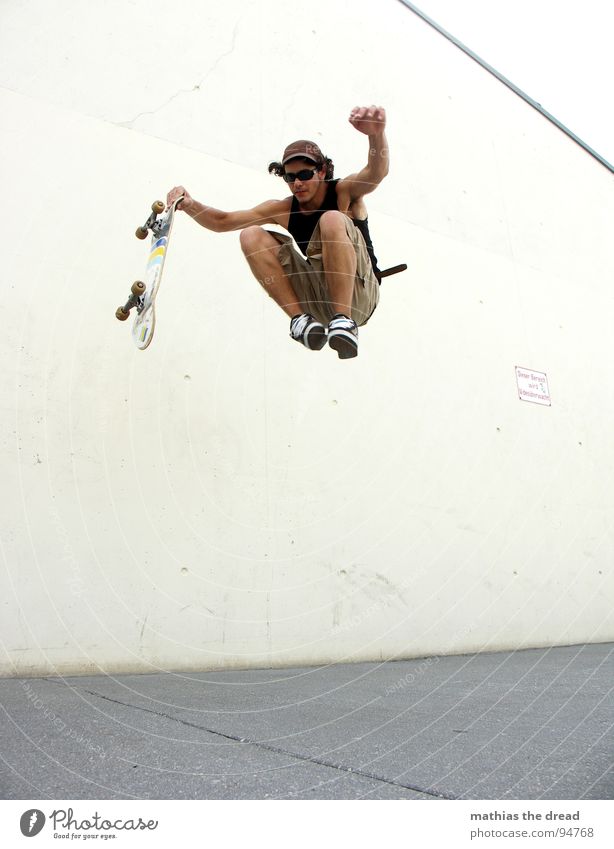 Flugversuch Sport belasten Gesundheit Freizeit & Hobby springen Skateboarding Beton Wand Licht Sonnenlicht Mann Junger Mann Mütze Shorts Sprungkraft gefährlich