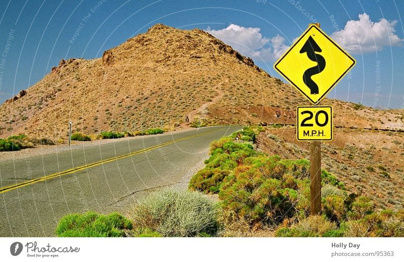 Tödliche Kurven Verkehrszeichen Death Valley National Park Kalifornien Wolken Sträucher Hügel Physik Sommer Verkehrswege Straßennamenschild Wüste Zeichen USA