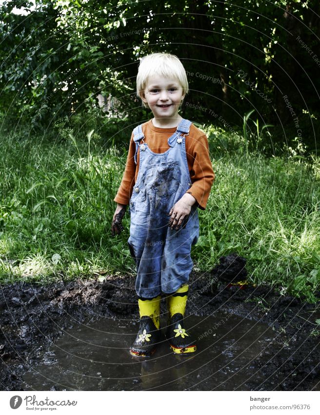 Matsch Pfütze Kind Gummi Stiefel nass Freude Wasser Regen dreckig Junge
