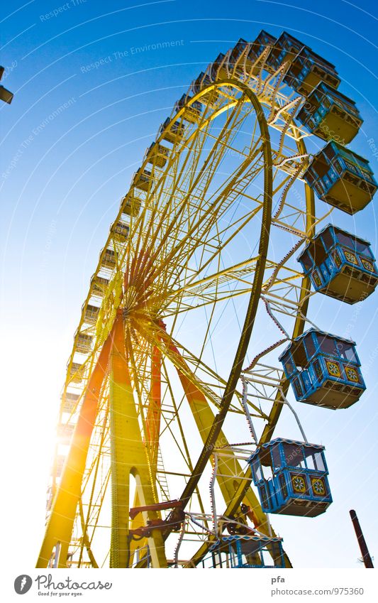 Riesenrad in der Sonne Jahrmarkt schaukeln frei hoch oben blau gelb Farbfoto mehrfarbig Außenaufnahme Textfreiraum links Tag Licht Sonnenlicht Sonnenstrahlen
