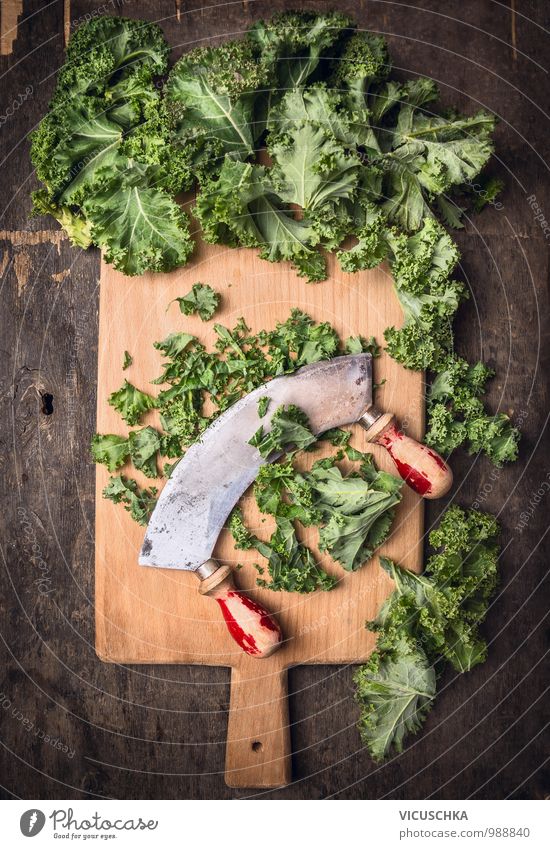 Grünkohl mit altem Wiegemesser hacken Lebensmittel Gemüse Salat Salatbeilage Stil Design Natur Kräutermesser rustikal Schneidebrett Holztisch Küchentisch dunkel