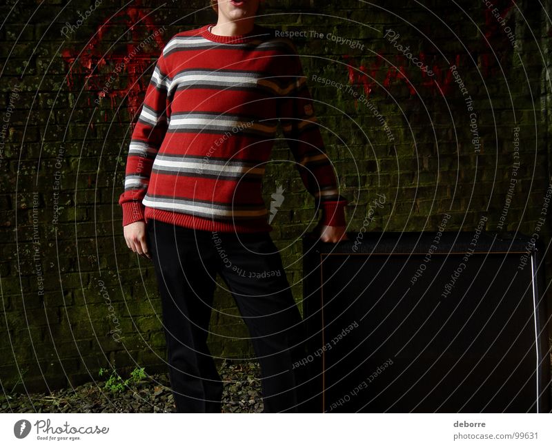 Junge steht neben einem Gitarrenverstärker in einem heruntergekommenen Eisenbahntunnel. gestreift Höhle Stollen rot schwarz dunkel Lautsprecher Verstärker