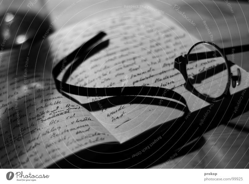 Notizbuch - II Zettel Brille lesen Buchstaben Handschrift poetisch geschlossen Gedicht Wort Tagebuch aufgeschlagen Tisch Tiefenschärfe unleserlich Kunst Kultur